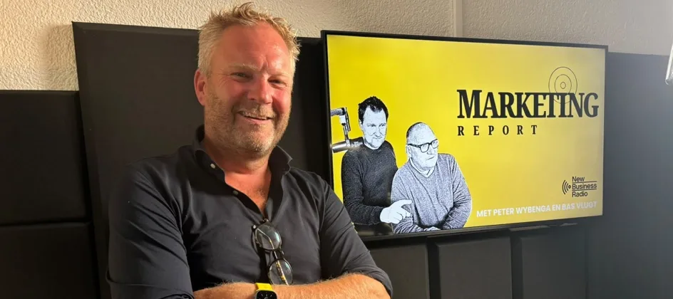 Bas Oudejans in the New Business Radio studio, in front of the Marketing Report screen